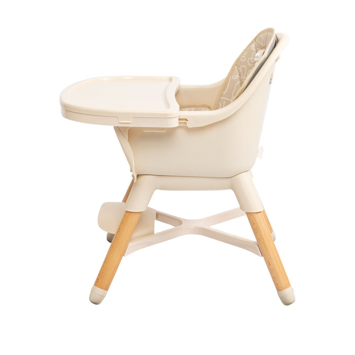 The Nuby 4-in-1 Multi-Use High Chair | Beige Lines features a padded leaf-patterned seat, built-in tray, and wooden legs with rubber tips. Shown side view on a white background, it’s designed to grow with your child.