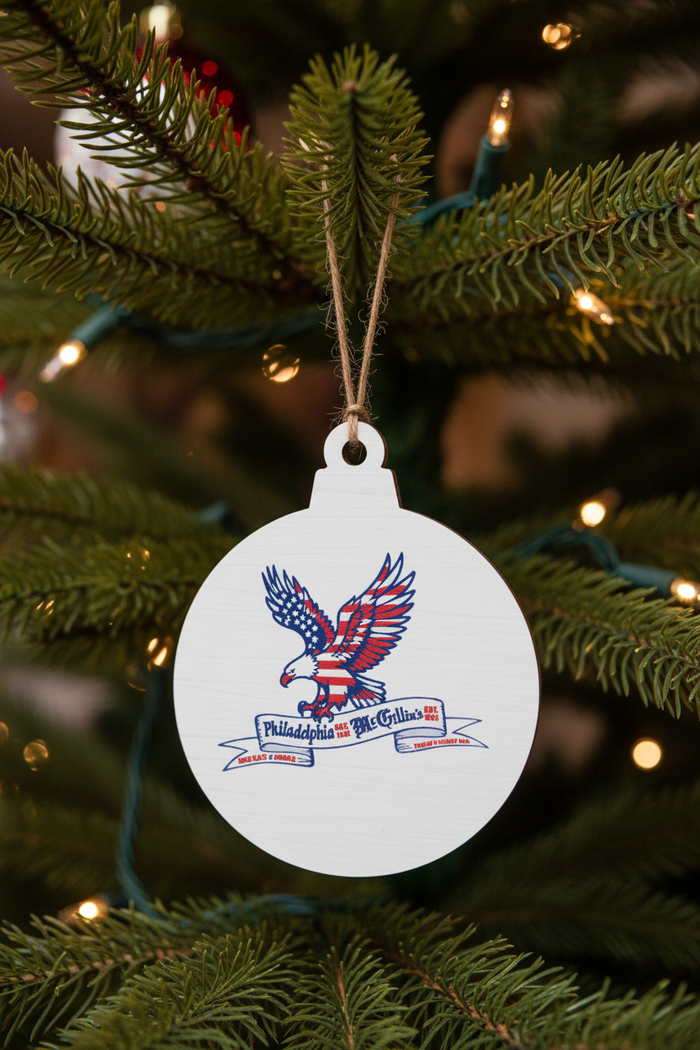 Round white tag with an eagle design and text, hanging on a string against a white background.