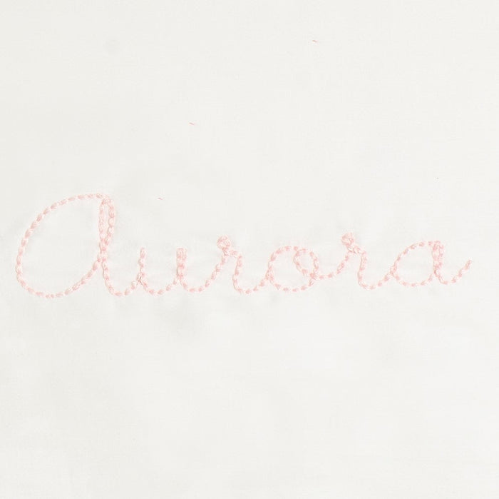 Monogram in pink color thread the name "Aurora"