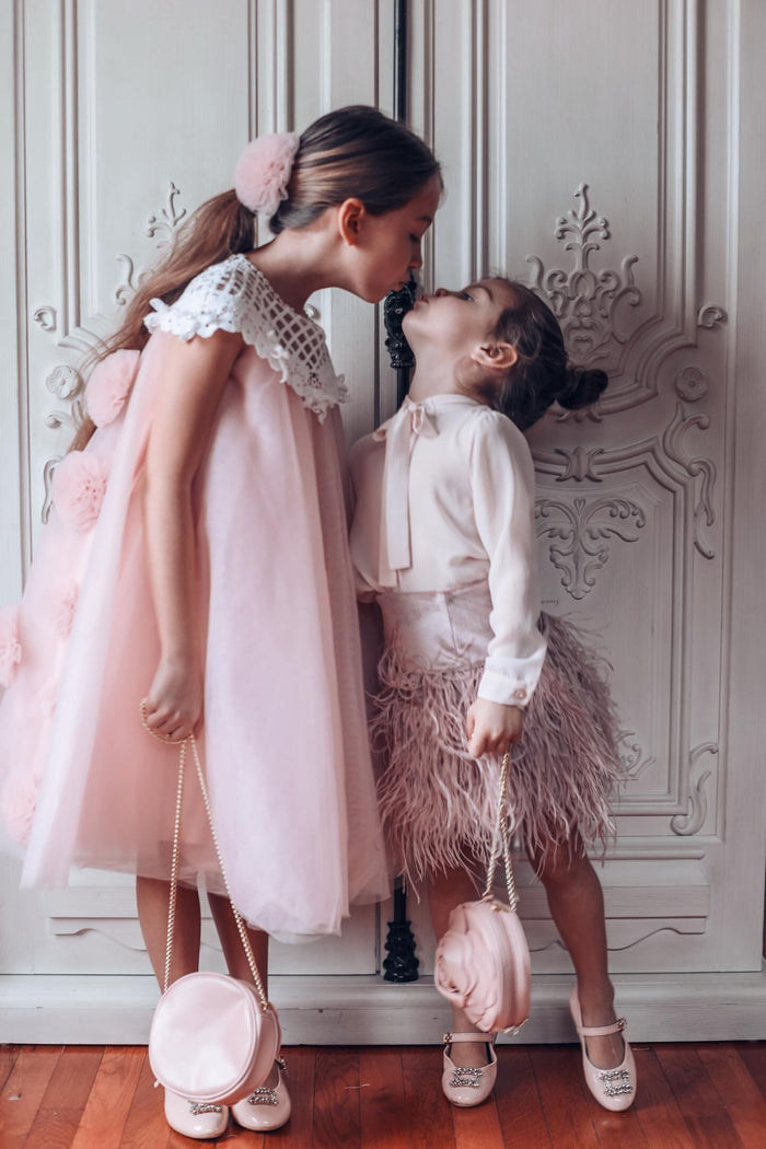 Rosa pink tulle flower hair clip styled on a child with a pink tulle dress, creating a coordinated and elegant look