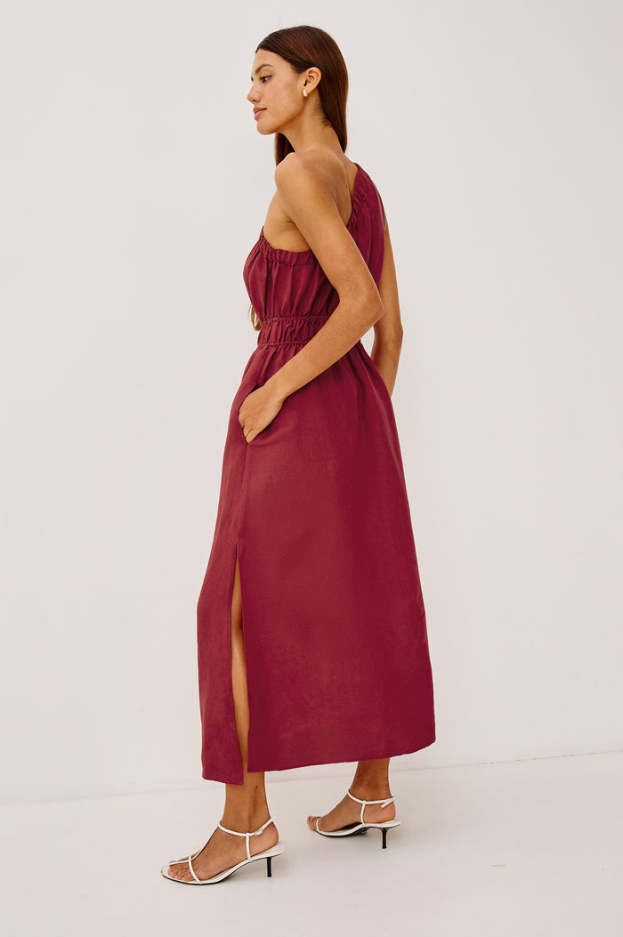 Selani Midi Dress in Linen-Viscose Blend With One-Shoulder Neckline, Laddered Elastic Waist, Side Slits, Side Pockets, and Softly Voluminous Skirt in Spice Colorway - Full Body Back View Featured on Model