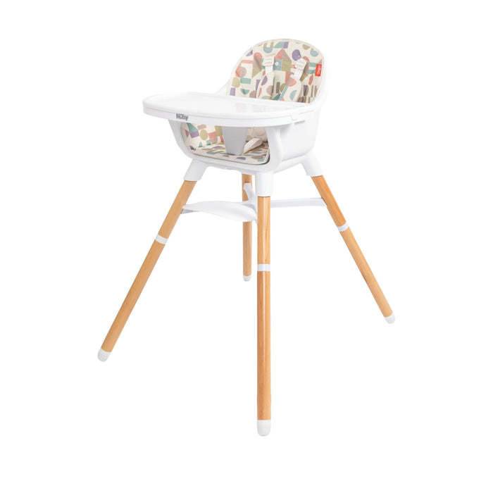 The Nuby 4-in-1 Multi-Use High Chair | White Geometrics features light wooden legs, a white seat and tray, and a vibrant geometric cushion. It adapts as your child grows for modern versatility and comfort.