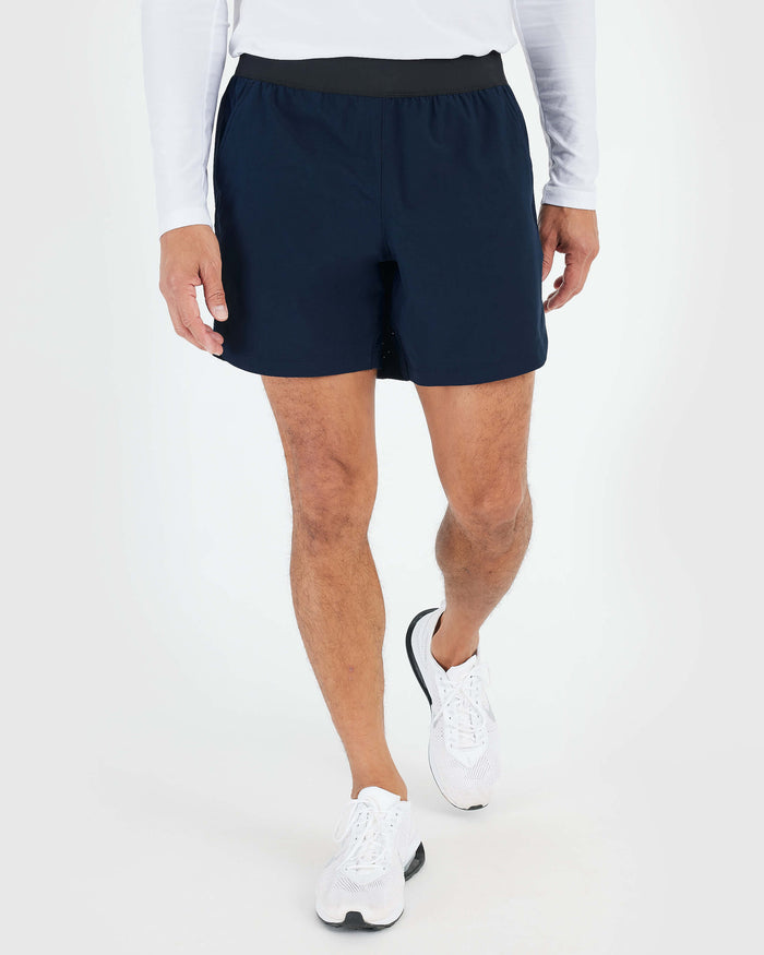 7 Navy Active Training Short on person walking, showcasing athletic fit.