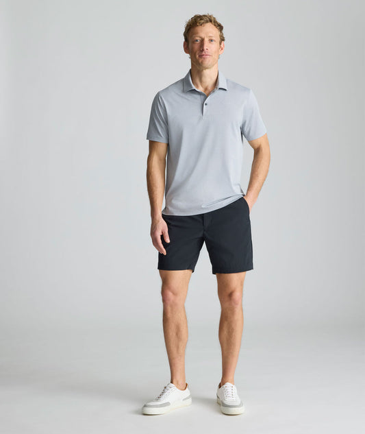 Model is wearing UNTUCKit 7" Traveler Tech Shorts in black.