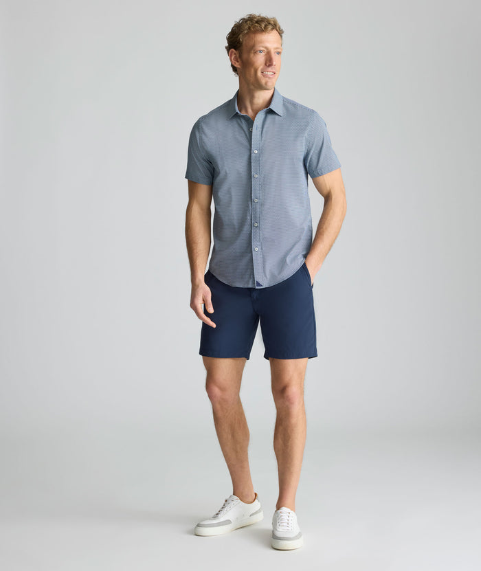 Model is wearing UNTUCKit 7" Traveler Tech Shorts in navy.