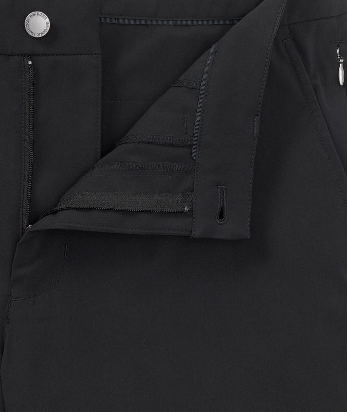 Model is wearing UNTUCKit 7" Traveler Tech Shorts in black.