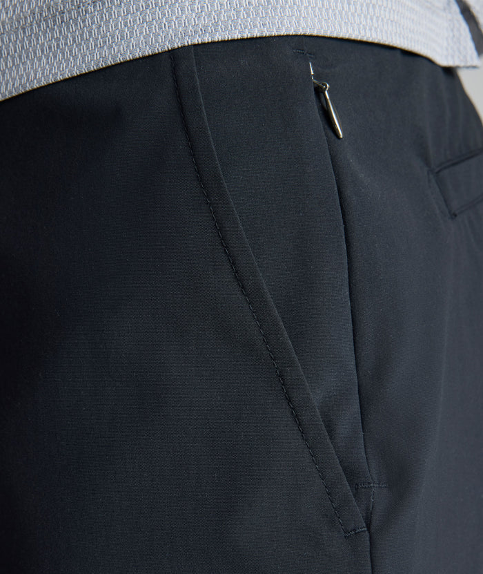 Model is wearing UNTUCKit 7" Traveler Tech Shorts in black.