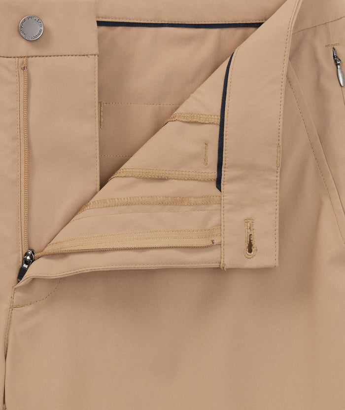 Model is wearing UNTCKit 7" Traveler Tech Shorts in Khaki.
