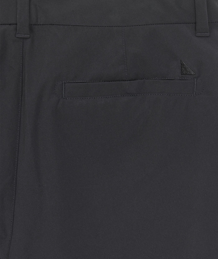 Model is wearing UNTUCKit 7" Traveler Tech Shorts in black.