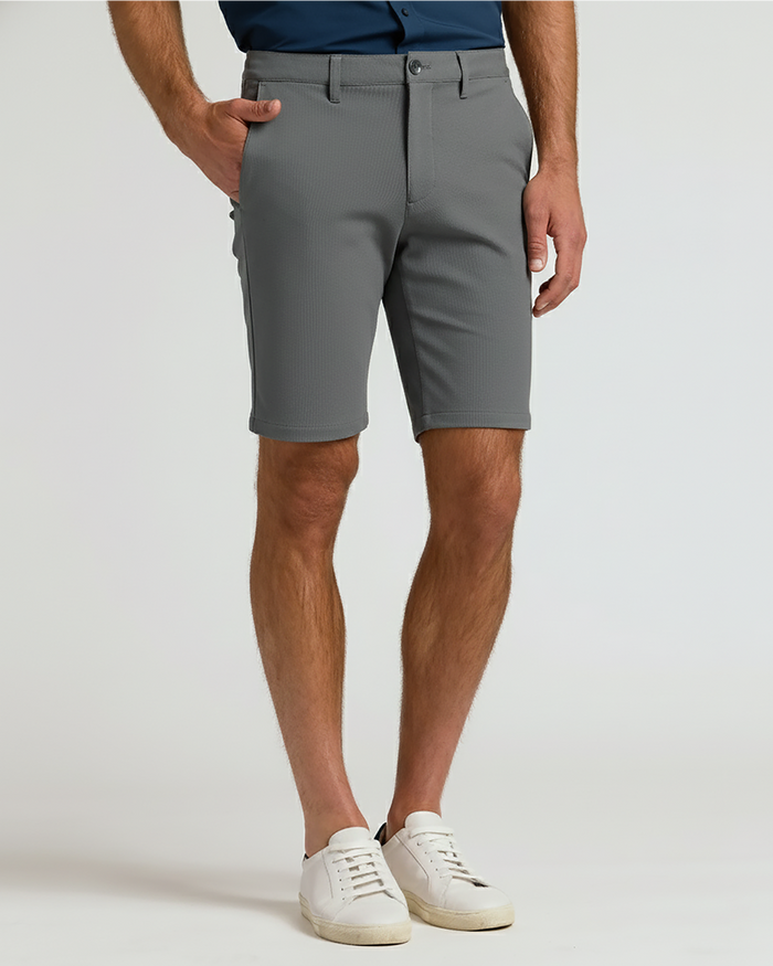 Man wearing 9 Carbon Chino Shorts 2.0 with white sneakers.