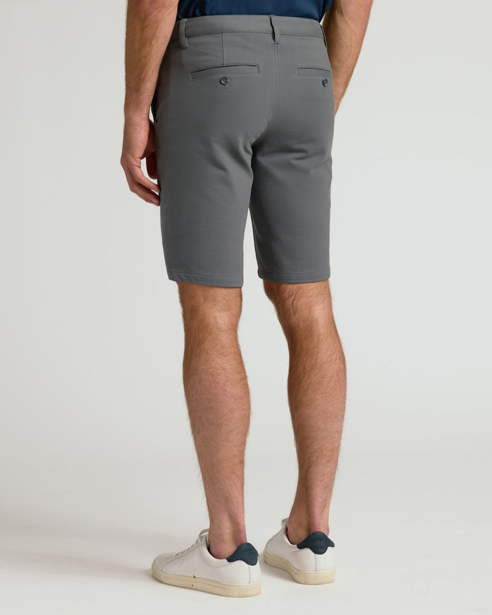 Man in 9 Carbon Chino Shorts 2.0, showcasing back welt pockets.