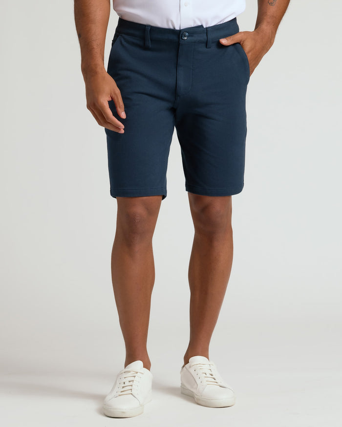 Man wearing 9 Navy Classic Chino Shorts 2.0 with white sneakers.