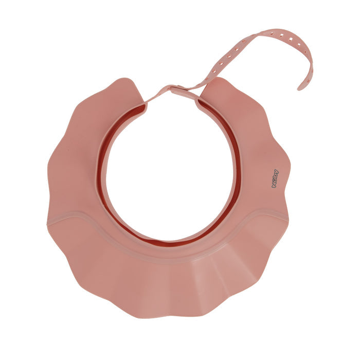 The Baby Bath Hat is a pink, flower-shaped silicone bib with an adjustable strap and wavy edge, inspired by bath hat designs, that helps babies or toddlers easily catch food spills.