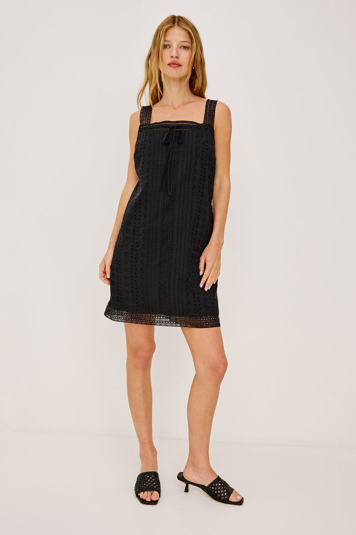 Beckton Mini Shirt Dress With Square Neckline, Eyelet Embroidery, Front Pintucks, Center-Front Ties, and Lace Shoulder Straps in Black Colorway - Full Body Front View Featured on Model