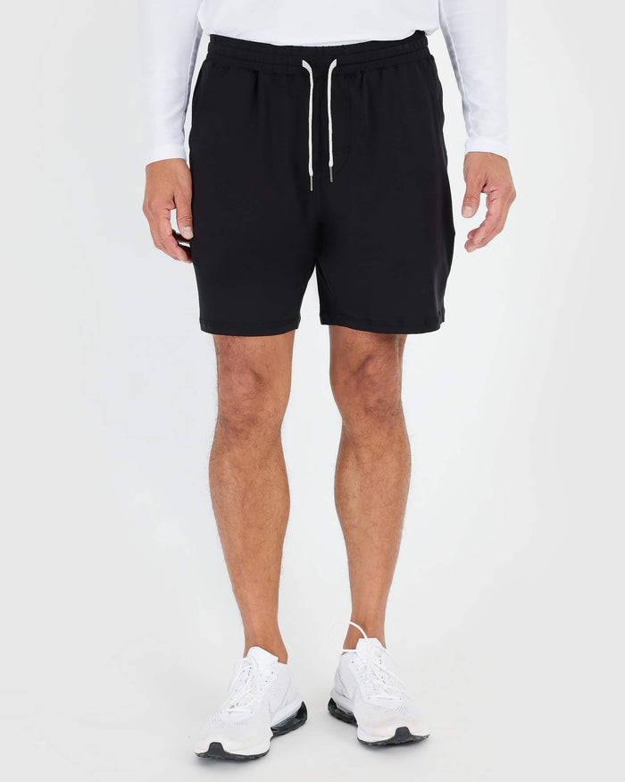 Man wearing Black Active Comfort Shorts with white drawstrings and sneakers.