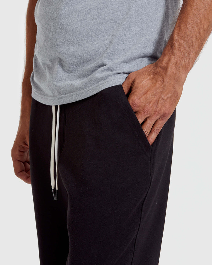 Black Fleece French Terry Joggers with white drawstring, hand in pocket.