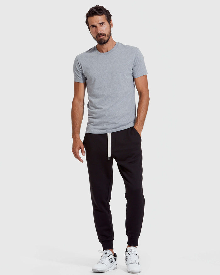 Man wearing Black Fleece French Terry Joggers with white sneakers.