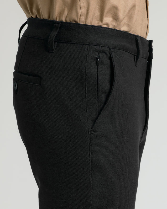 Black Slim Chino Pants 2.0 with tucked-in tan shirt, side, and rear pockets.