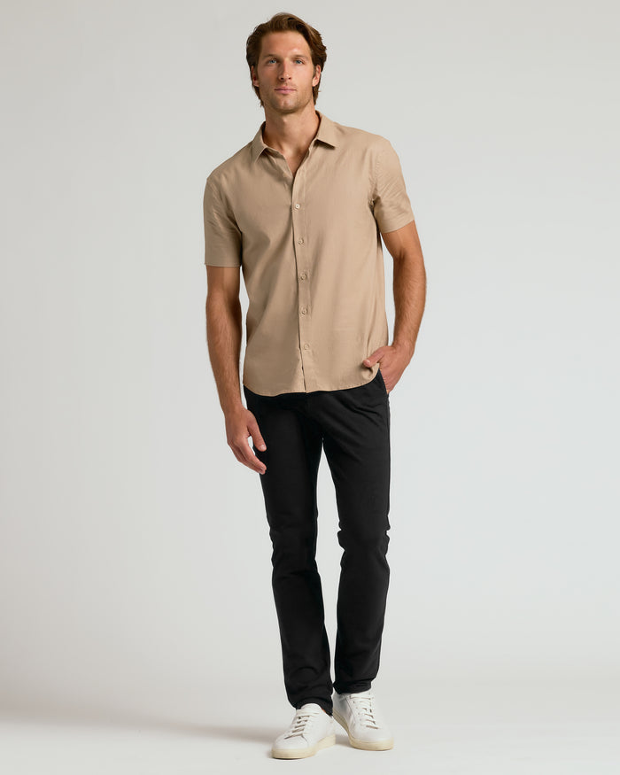 Man wearing Black Slim Chino Pants 2.0 with white sneakers.