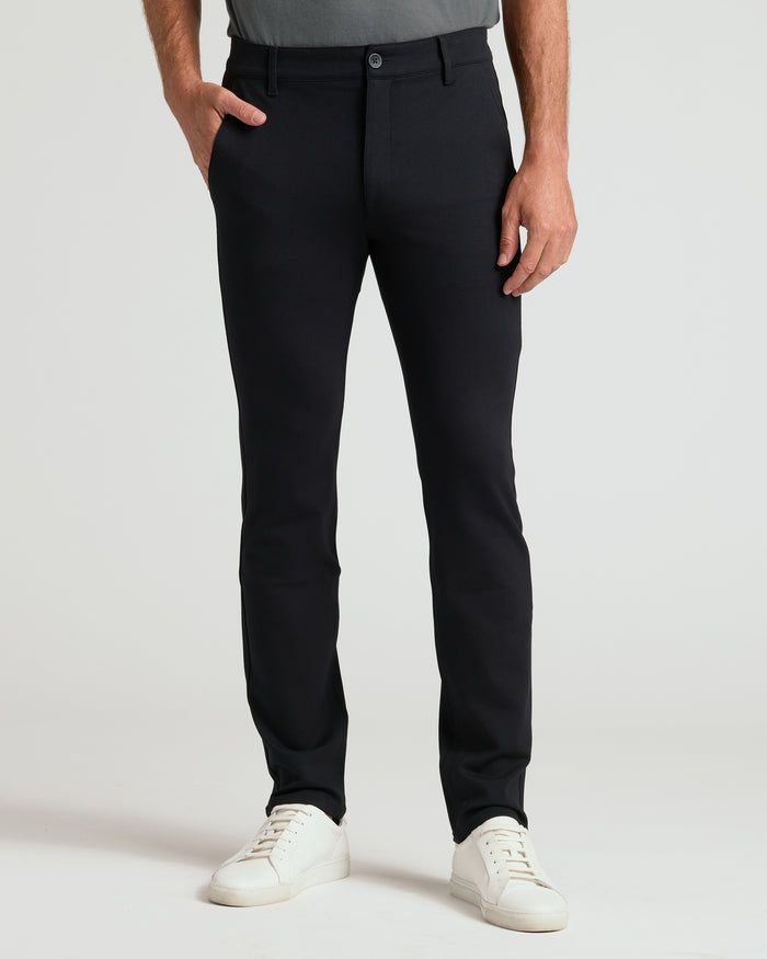 Black Slim Comfort Knit Chino Pant with white sneakers, model's hand in pocket.