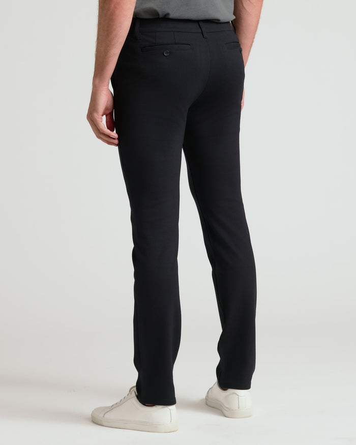 Black Slim Comfort Knit Chino Pant with welt pockets and white sneakers.