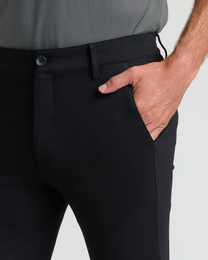 Black Slim Comfort Knit Chino Pant with hand in pocket, buttoned waistband.