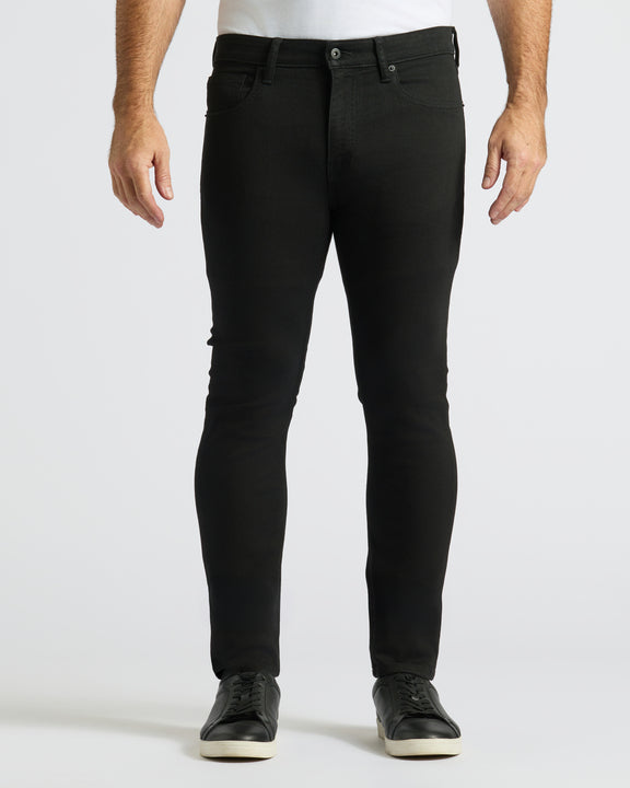 Slim-fit Black Wash Comfort Stretch Jeans with black low-top sneakers.