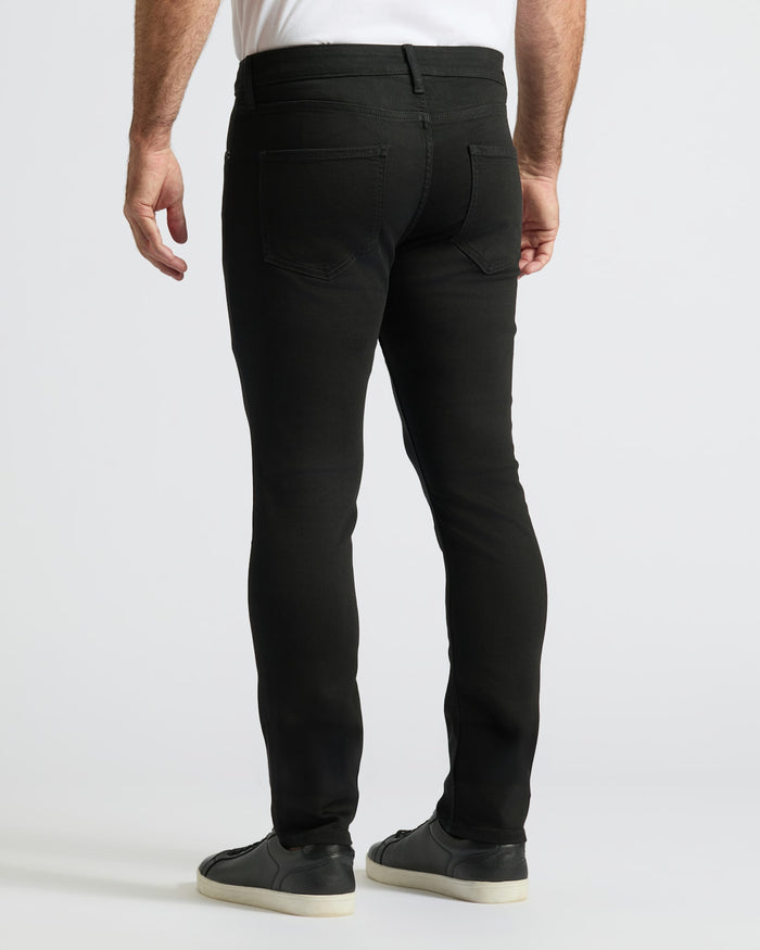 Black Wash Slim Comfort Stretch Jeans with black sneakers, white shirt peeking.