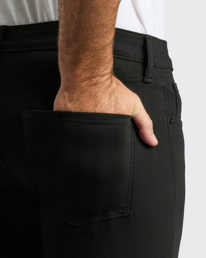 Hand in back pocket of Black Wash Slim Comfort Stretch Jeans.