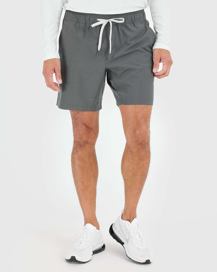 Man wearing Carbon Active Quick Dry Shorts with white sneakers.
