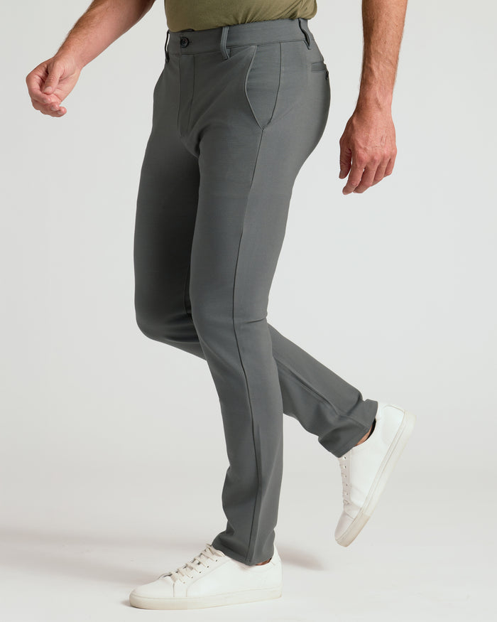 Carbon Slim Comfort Knit Chino Pant with white sneakers, mid-step.