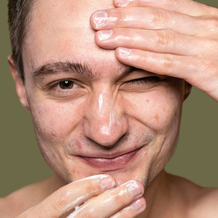 white young man applying facial cleanser dermal essentials medical grade skincare