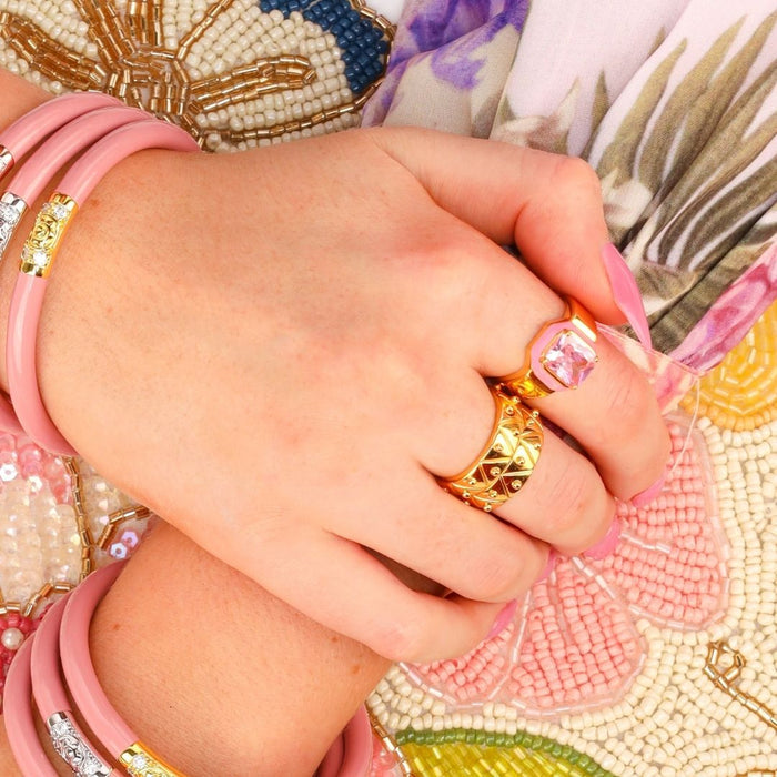 a close-up of a hand with pink bracelets