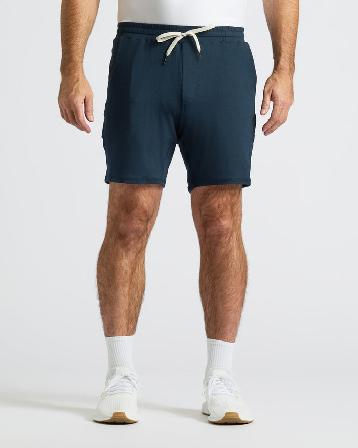 Man wearing Dark Heather Navy Active Comfort Shorts, white socks, and sneakers.