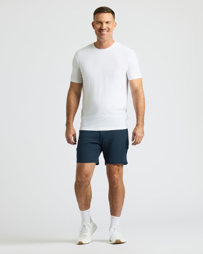 Man wearing Dark Heather Navy Active Comfort Shorts, white T-shirt, sneakers.