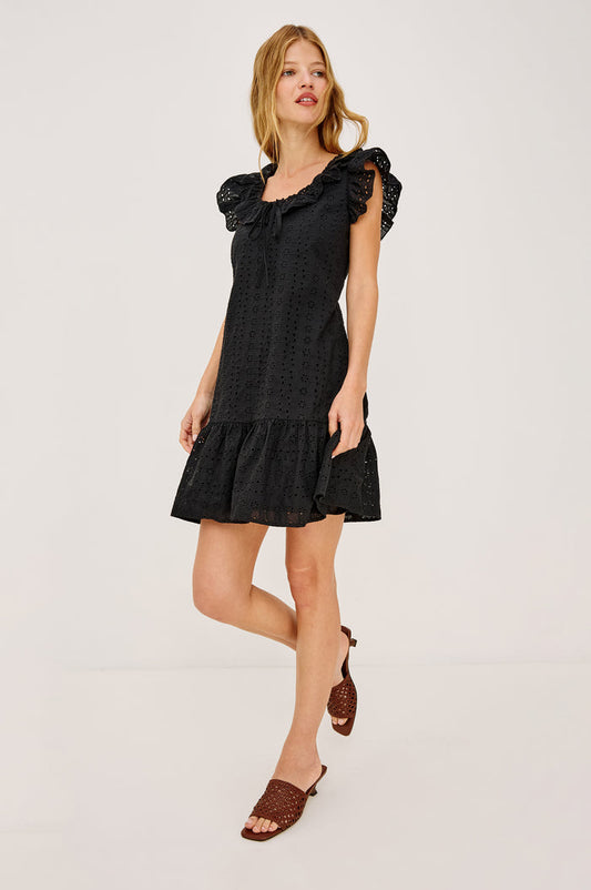 Essie Mini Dress in Cotton Voile With Eyelet Detailing, A-Line Silhouette, Wide Scoop Neckline With Ruffle Trim, Flutter Sleeves, and is Fully Lined in Black Eyelet Colorway - Upper Body Front View Featured on Model