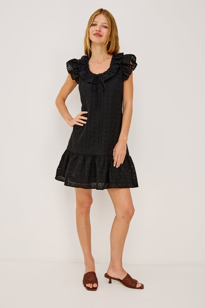 Essie Mini Dress in Cotton Voile With Eyelet Detailing, A-Line Silhouette, Wide Scoop Neckline With Ruffle Trim, Flutter Sleeves, and is Fully Lined in Black Eyelet Colorway - Full Body Front View Featured on Model