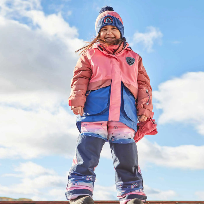 Girl wearing Deux par Deux Coral Pink two-piece snowsuit during outdoor snow play