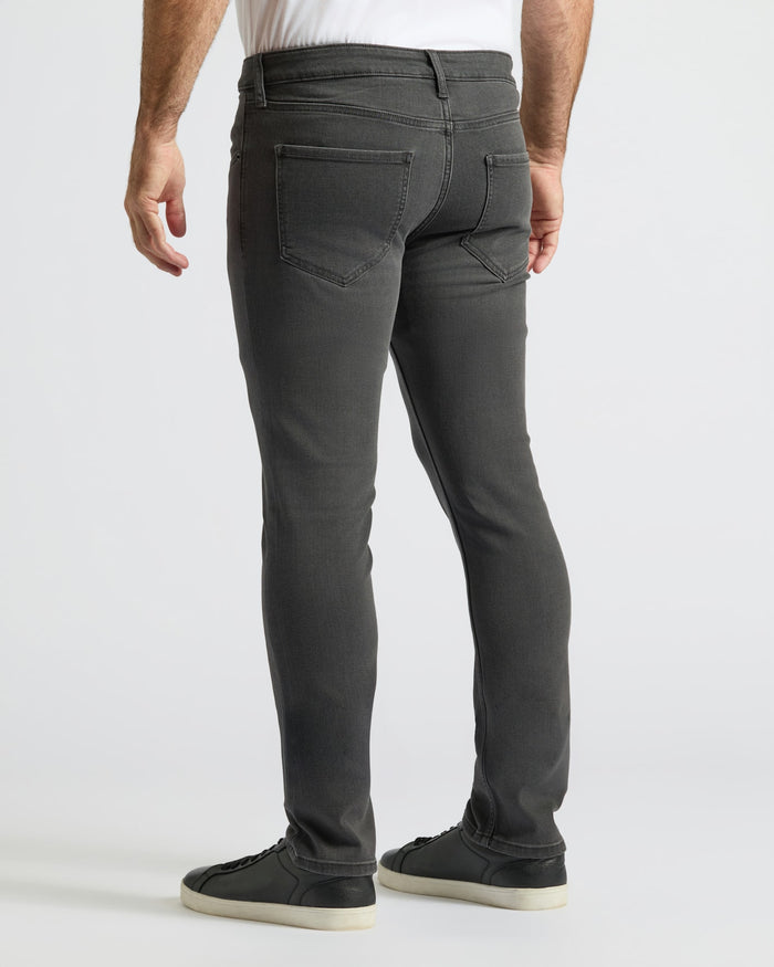 Gray Wash Slim Comfort Stretch Jeans worn with white shirt and black sneakers.