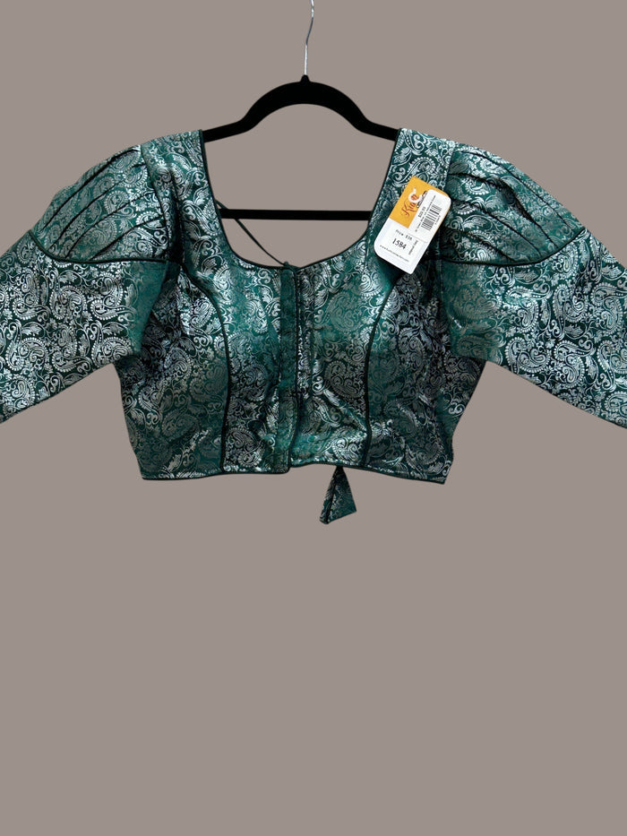 Kurti Connection USA emerald green and silver brocade blouse with puff sleeves and a square neckline on a hanger