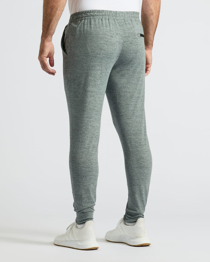 Heather Gray Active Joggers modeled with white sneakers, studio setting.