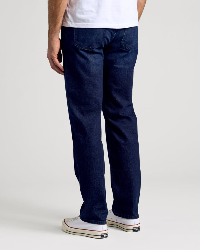 Indigo Rinse Straight Authentic Denim Jeans, back view with white sneakers.