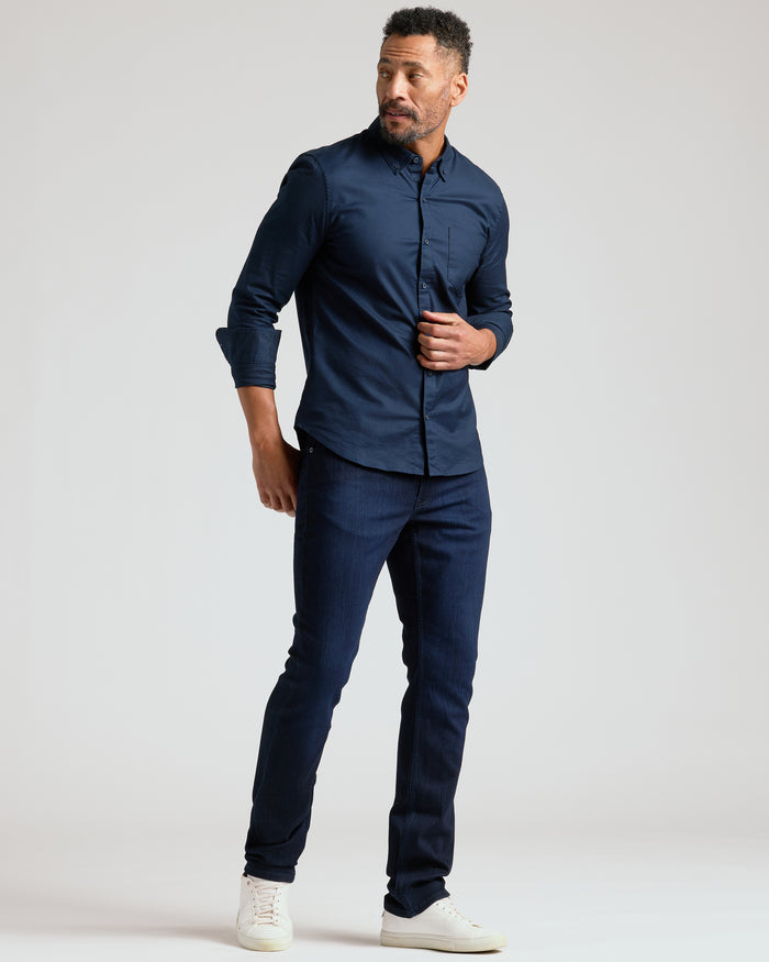Man wearing Indigo Wash Straight Comfort Stretch Jeans, dark shirt, and white sneakers.