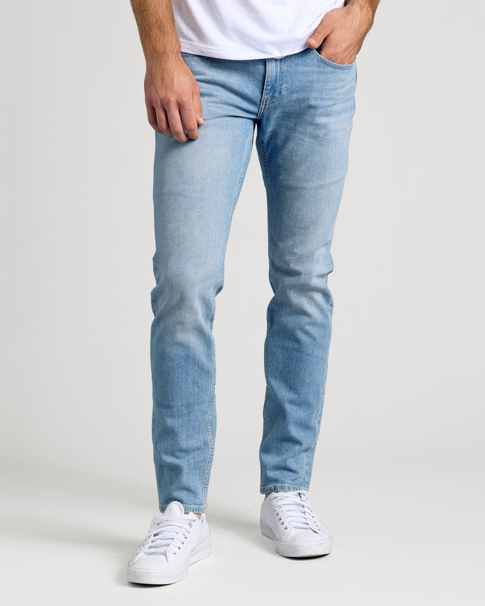 Light Indigo Wash Slim Authentic Denim Jeans modeled with white sneakers.