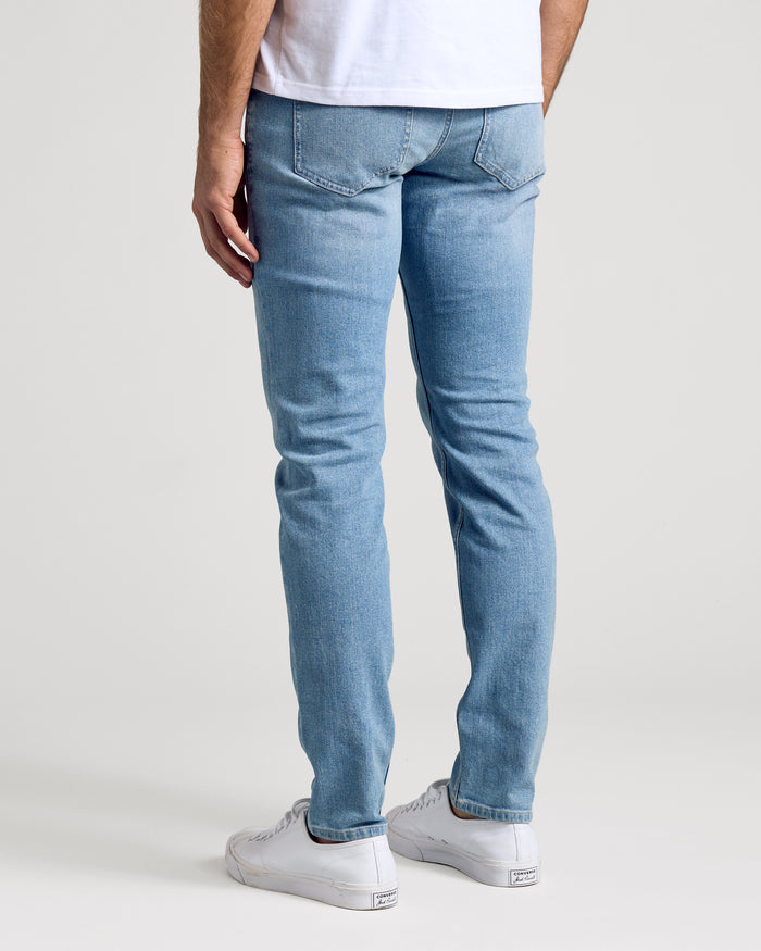 Light Indigo Wash Slim Authentic Denim Jeans with white low-top sneakers.