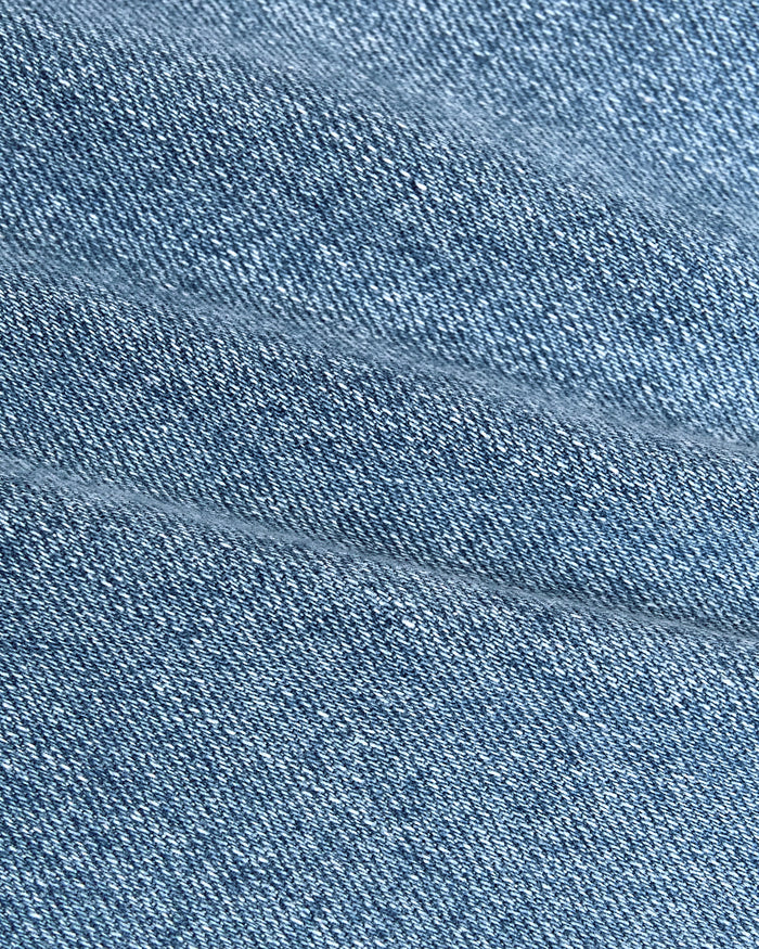 Light Indigo Wash Straight Authentic Denim Jeans close-up, showing woven texture and seam.