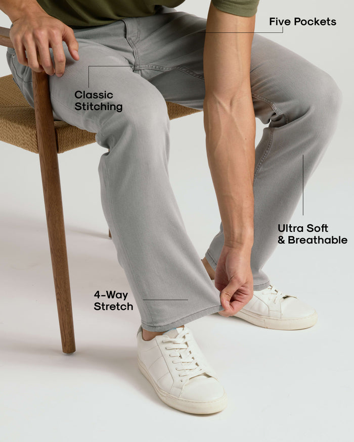 Man wearing Medium Gray Wash Straight Comfort Stretch Jeans, demonstrating fabric's stretch.