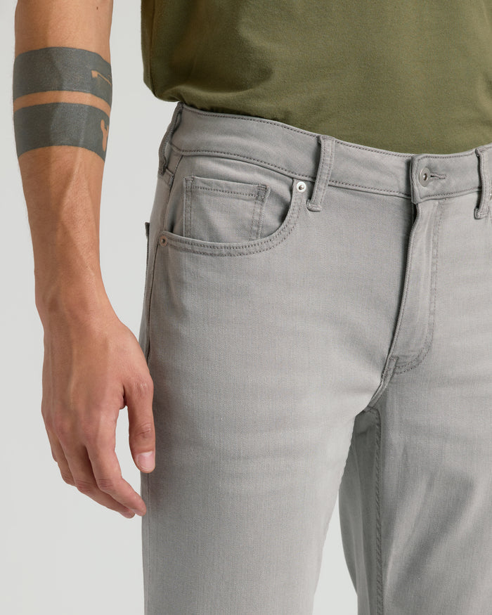 Medium Gray Wash Straight Comfort Stretch Jeans with front pockets and a tucked-in olive-green shirt.