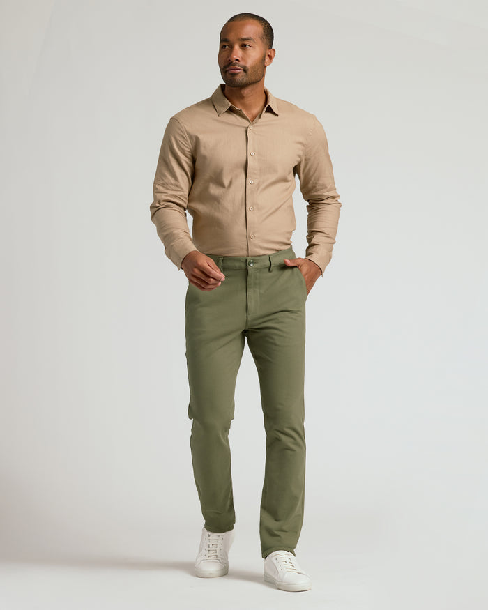 Model wearing Military Green Slim Chino Pants 2.0, mid-stride stance.