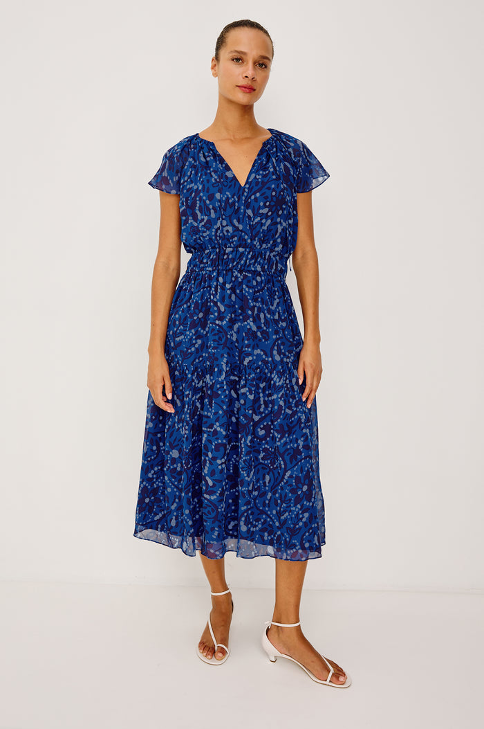 Mirielle Maxi Dress in Chiffon With V-Neckline, Elastic Waist, Center Front Ties, Raglan Short Sleeves, Single Tier Skirt and is Fully Lined - Full Body Front View Featured on Model